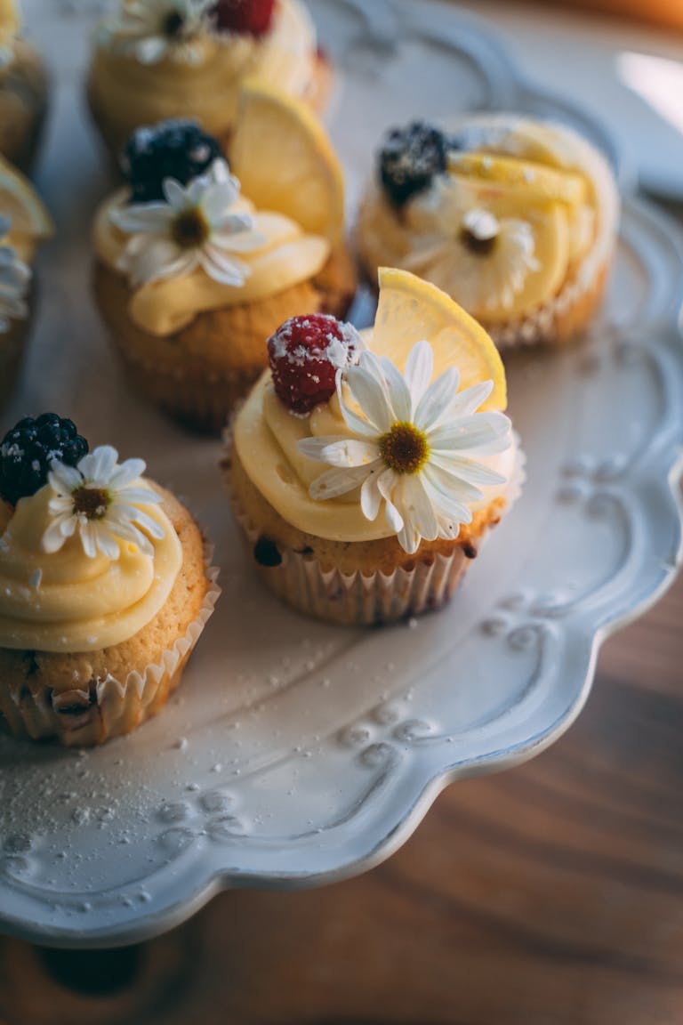 Savor the delight of beautifully decorated cupcakes with berries and flowers.