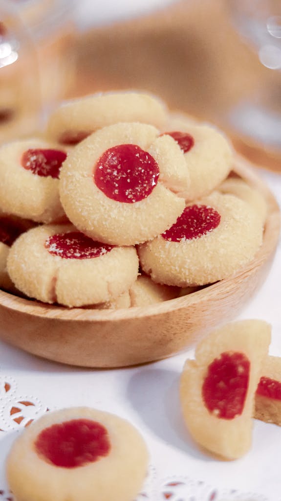Tasty raspberry butter cookies stacked in a wooden bowl, perfect for dessert lovers.