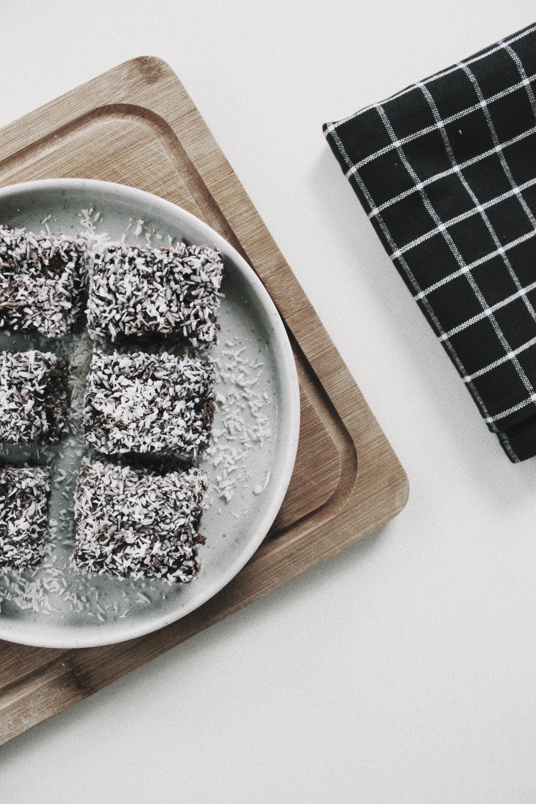 High-angle shot of chocolate lamingtons recipe with coconut on a ceramic plate, perfect for dessert presentations.
